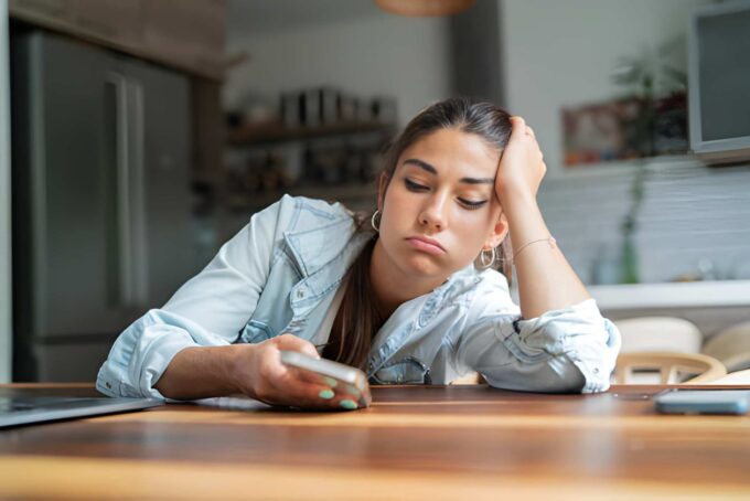 Bored woman looking at her phone