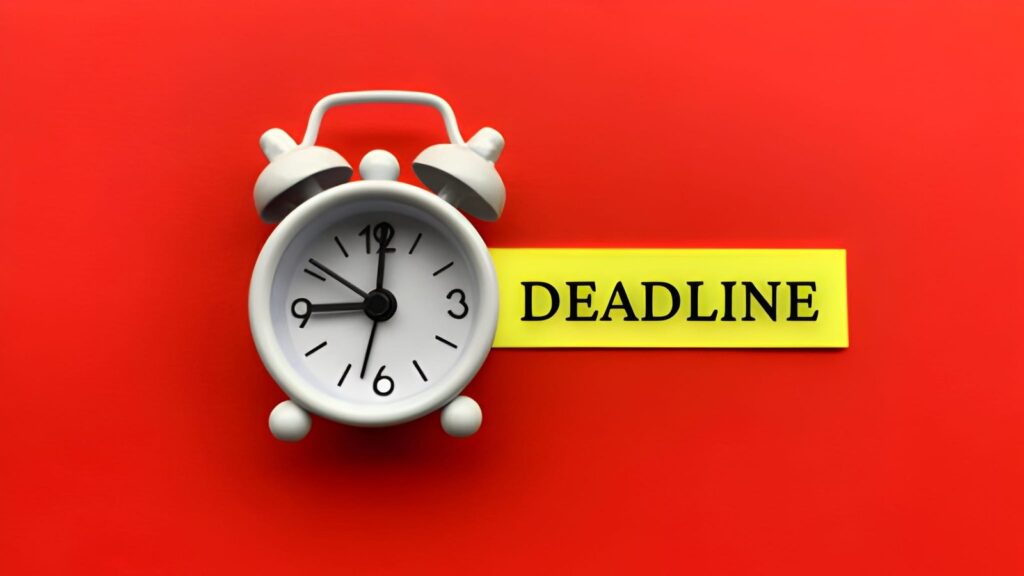 white-alarm-clock-with-text-deadline-on-sticky-note-with-red-background