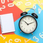 alarm-clock-lying-on-multicolored-surface