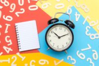 alarm-clock-lying-on-multicolored-surface