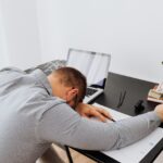 Bored man sleeping at his work desk