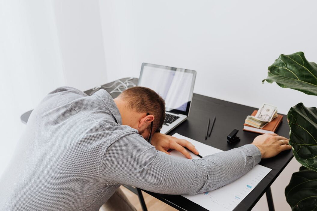 Bored man sleeping at his work desk