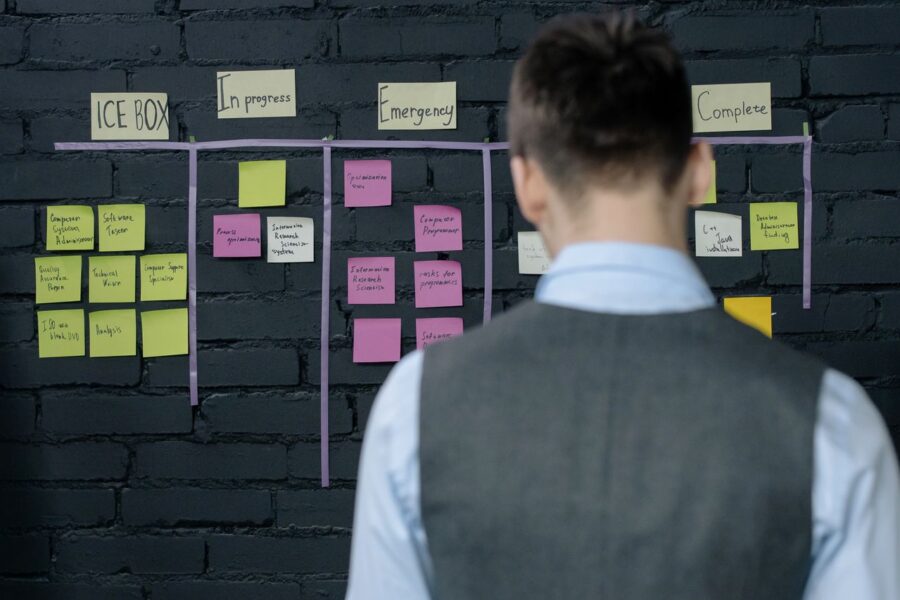 man-in-suit-vest-standing-near-black-wall-with-sticky-notes